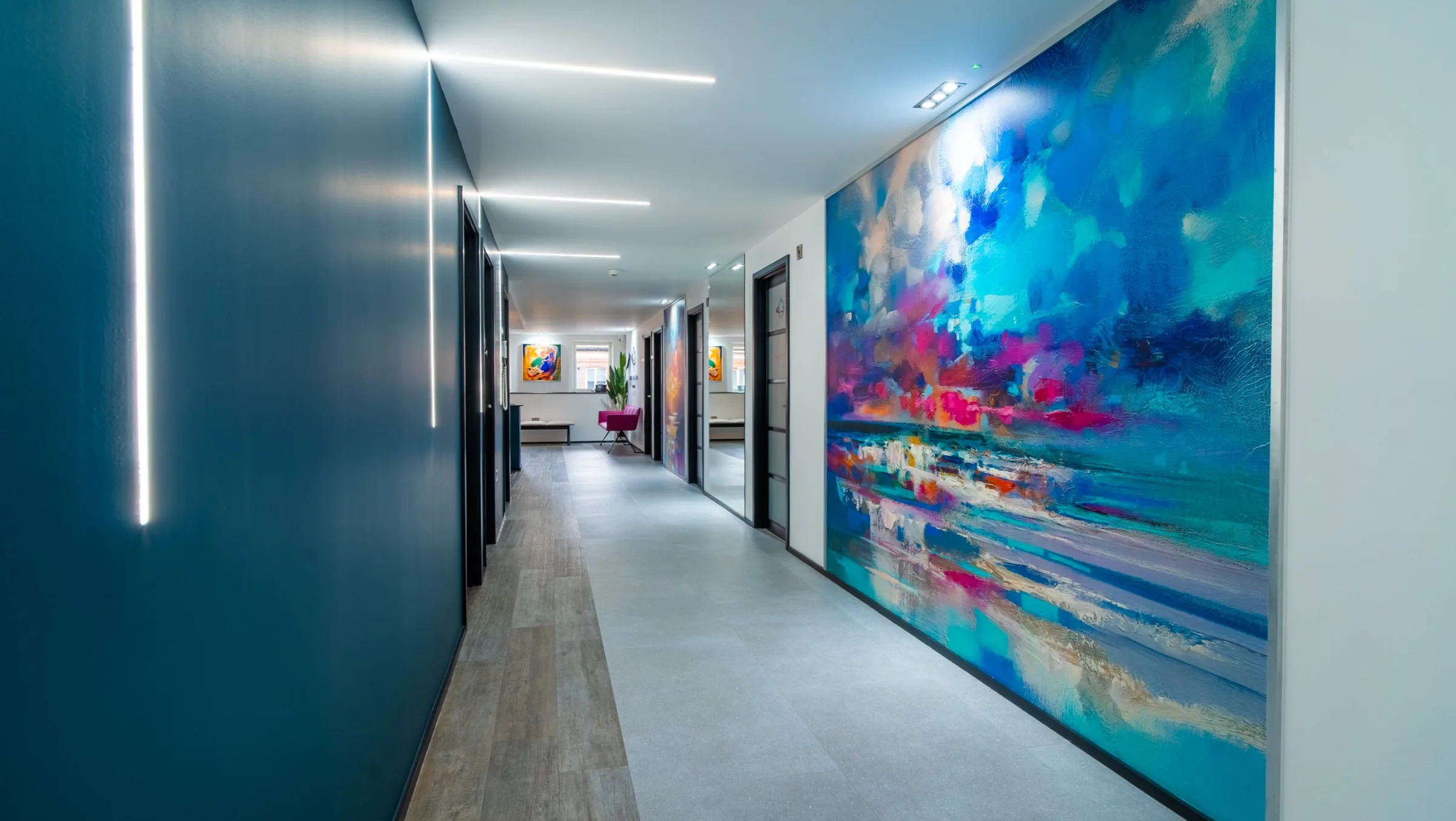 Corridor to the treatment rooms at Hove Dental Clinic, with a large colourful painting on the wall.