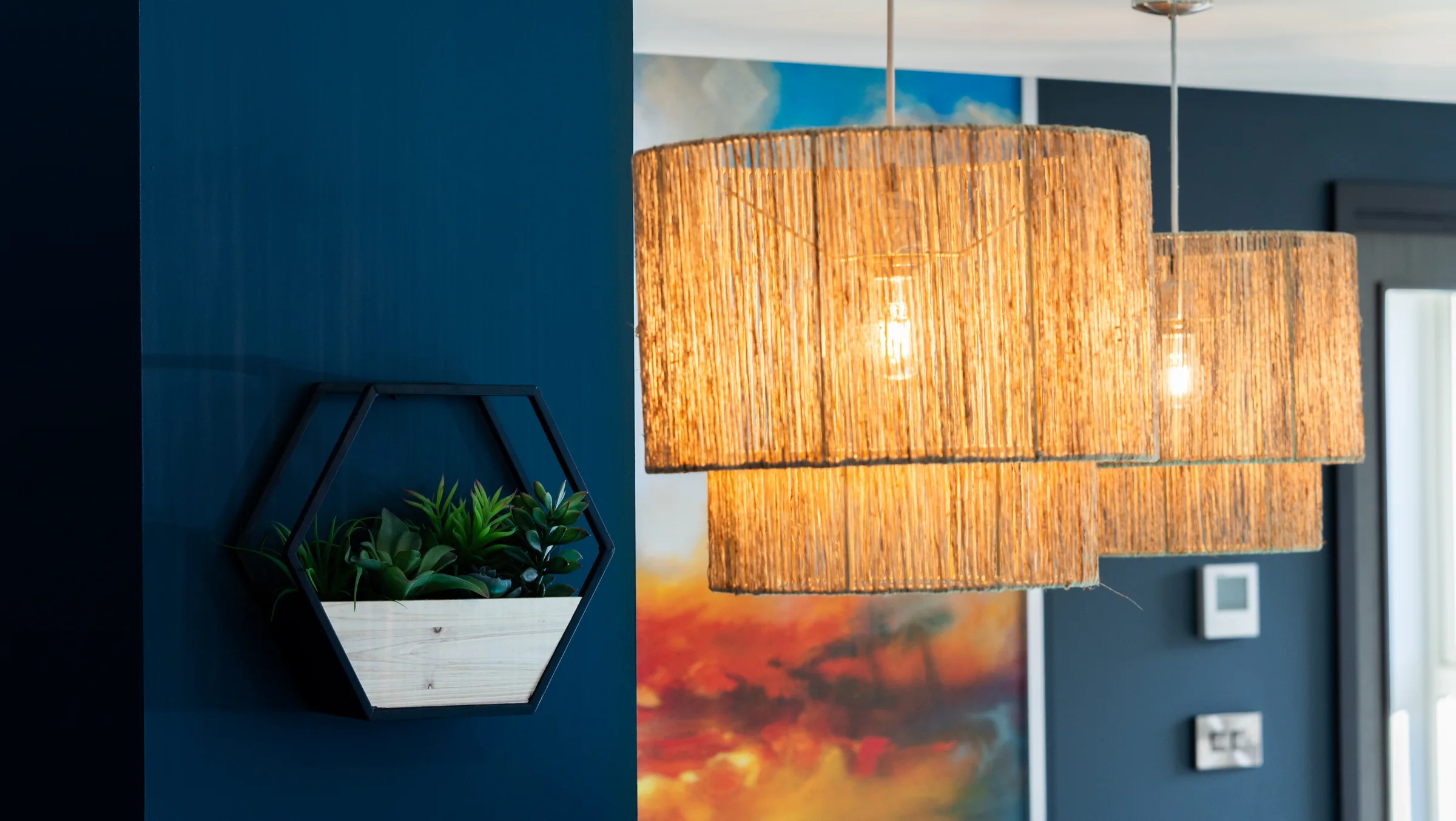 Warm pendant lights and a wall planter in the reception area at Hove Dental Clinic